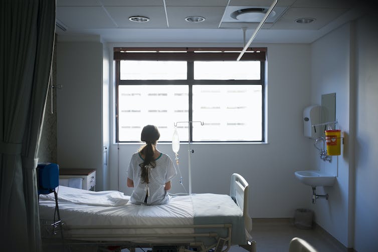 Patient sitting on hospital bed looking out the window